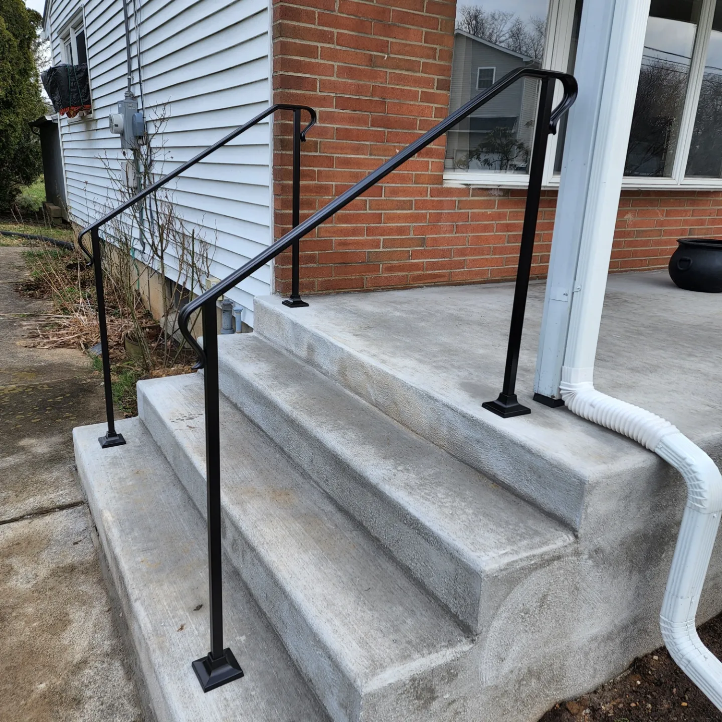 small stone stairs with black railing