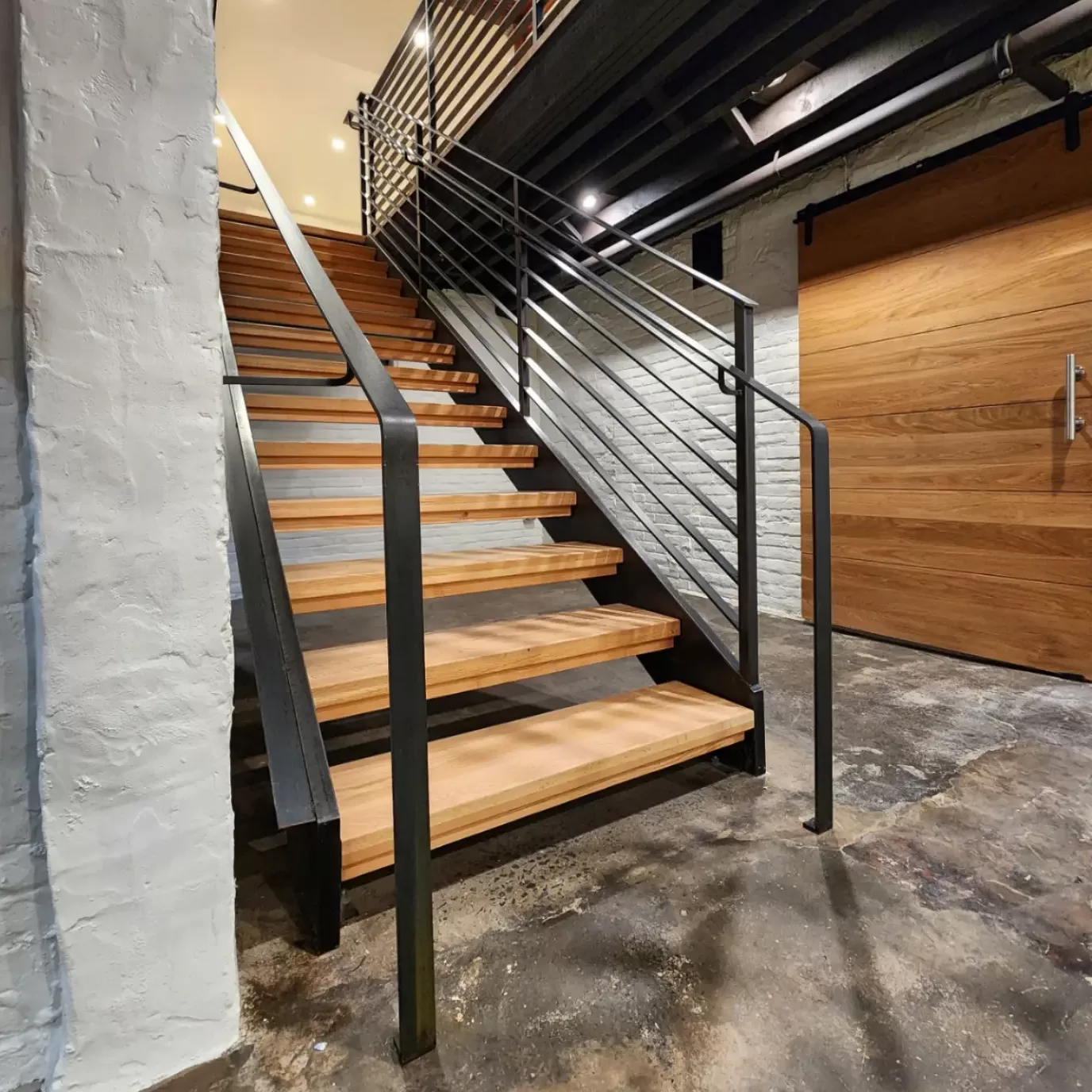 Modern wooden staircase with metal structure and railing