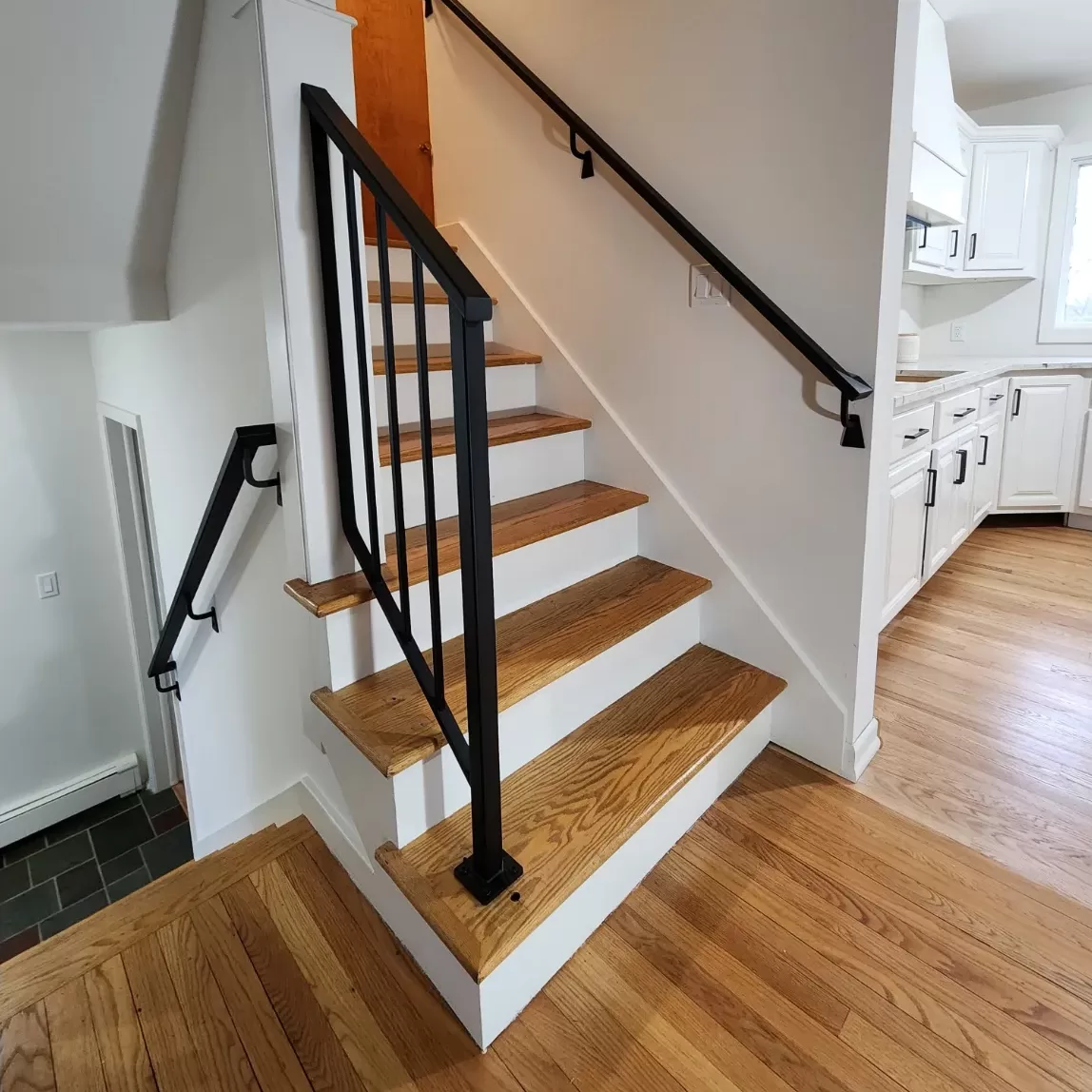 Home's interior wooden staircase with black metal railing